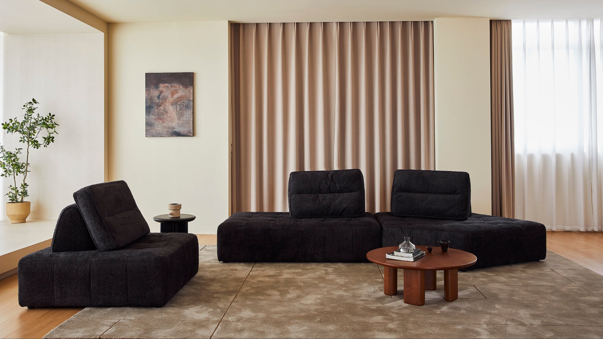 Modern living room with black sofa, wooden coffee table, and decorative elements.