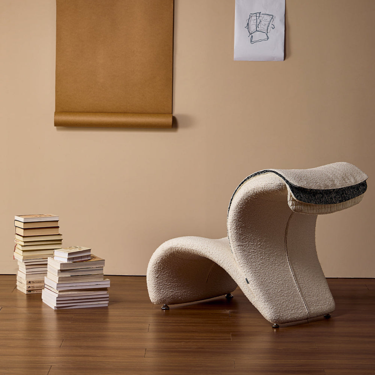Modern wavy chair in a room with books and a painting on the wall.