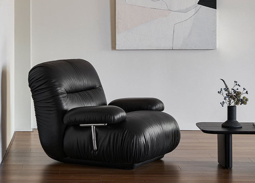 Black leather armchair in a living room with abstract art on the wall.