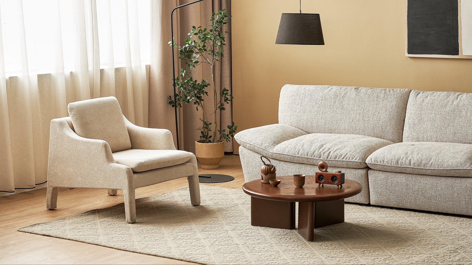 Modern living room with beige armchair, sofa, and coffee table.