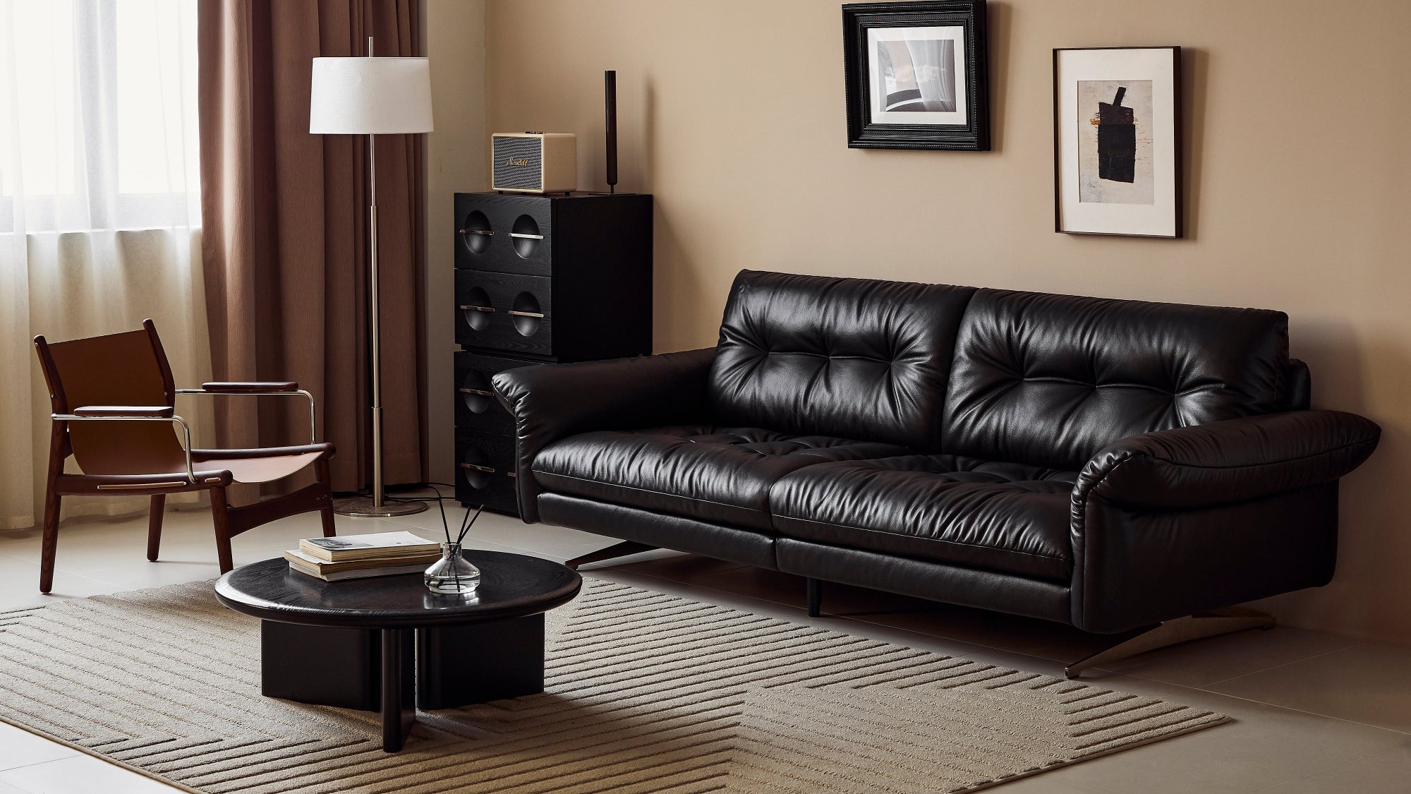 Living room with a black leather sofa, coffee table, and wall art.