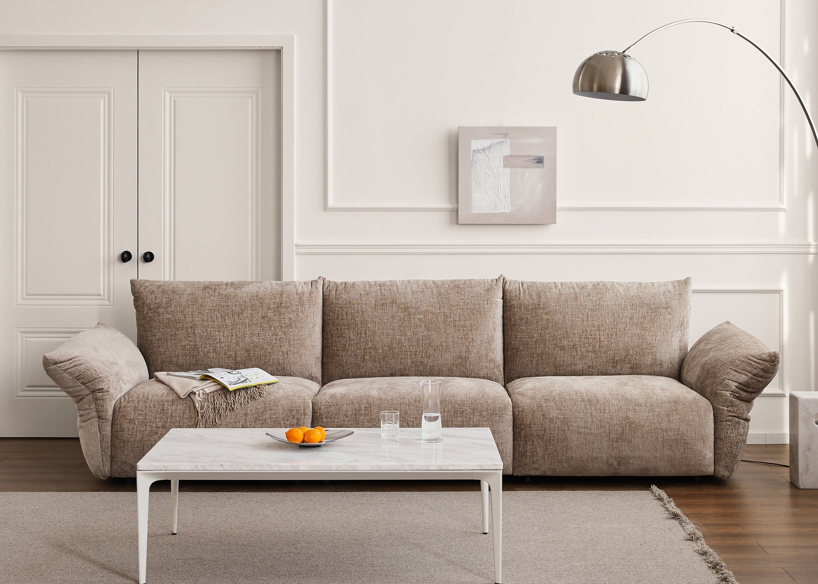 Beige sectional sofa in a living room with a coffee table and decor items.