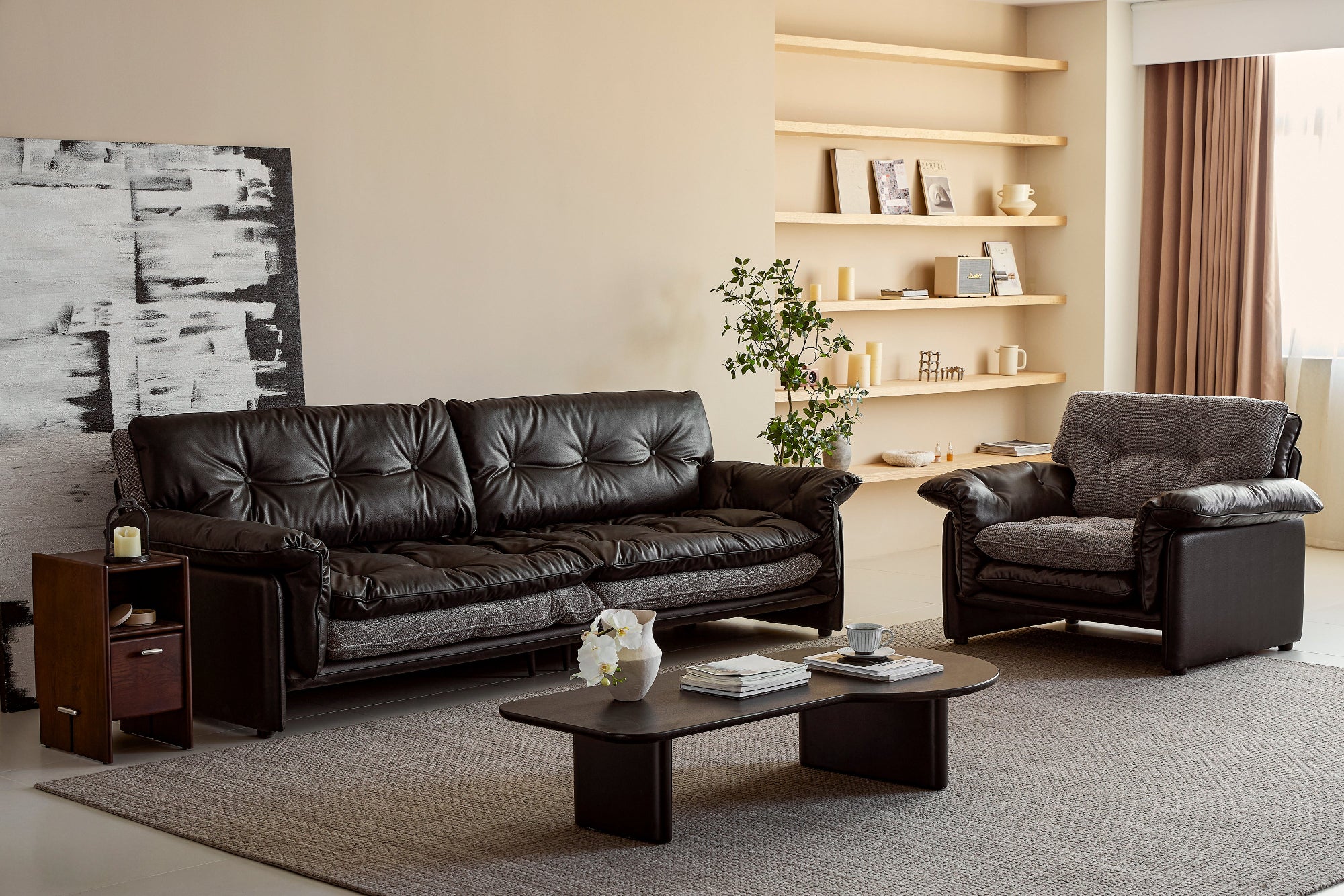 Modern living room with a black leather sofa, armchair, and coffee table.