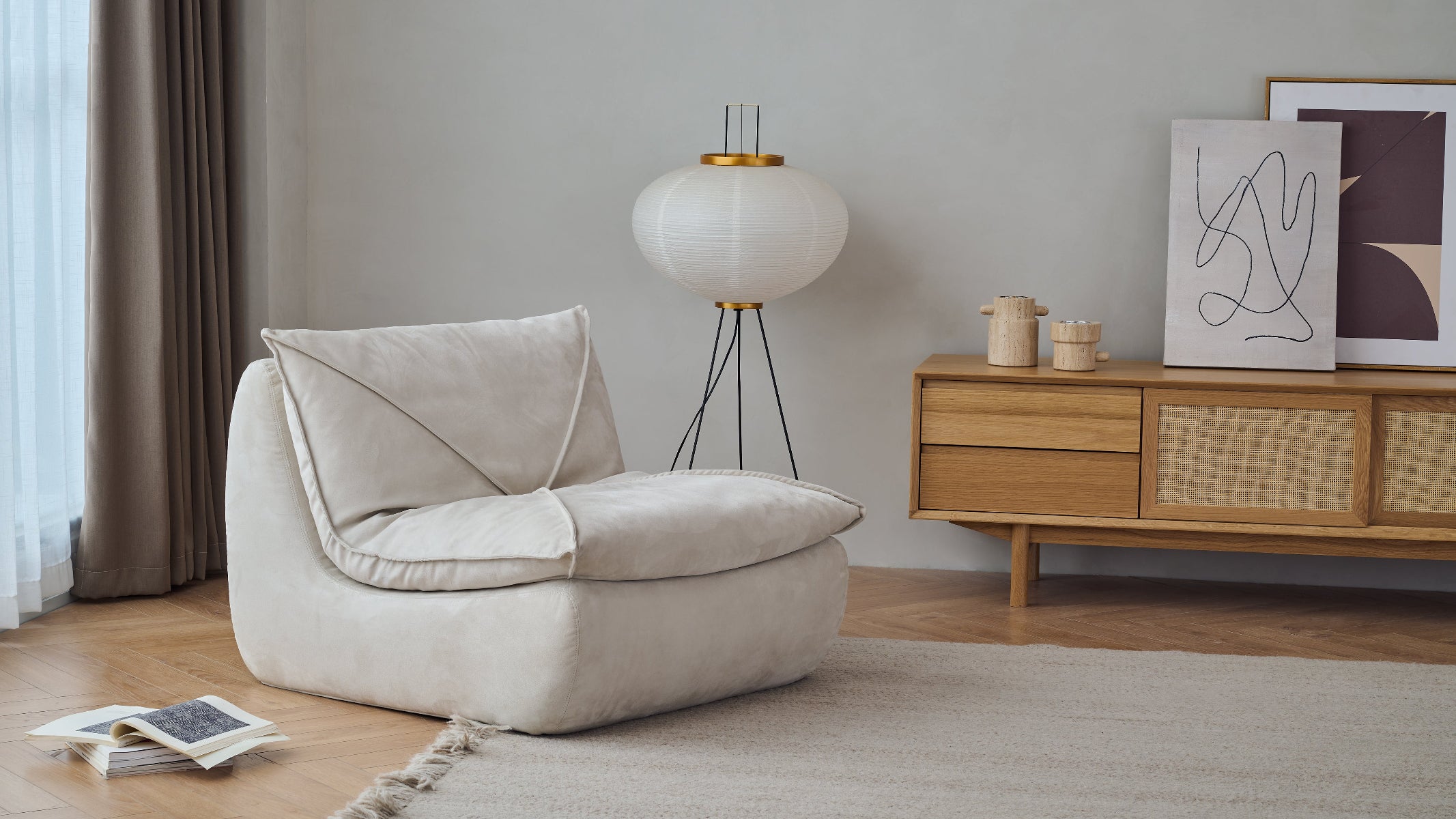 Beige armchair in a modern living room with a wooden sideboard and decorative items.